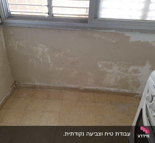 עבודת שפכטל והחלקת קיר מתחת לחלון כהכנה לצביעה